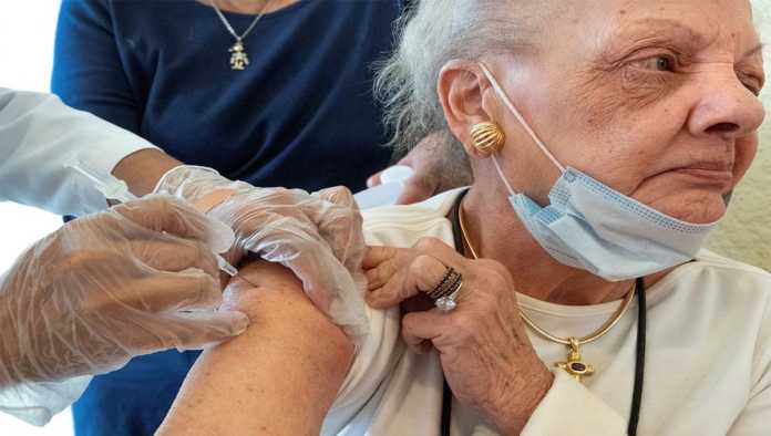 Anciana recibe la vacuna contra COVID-19