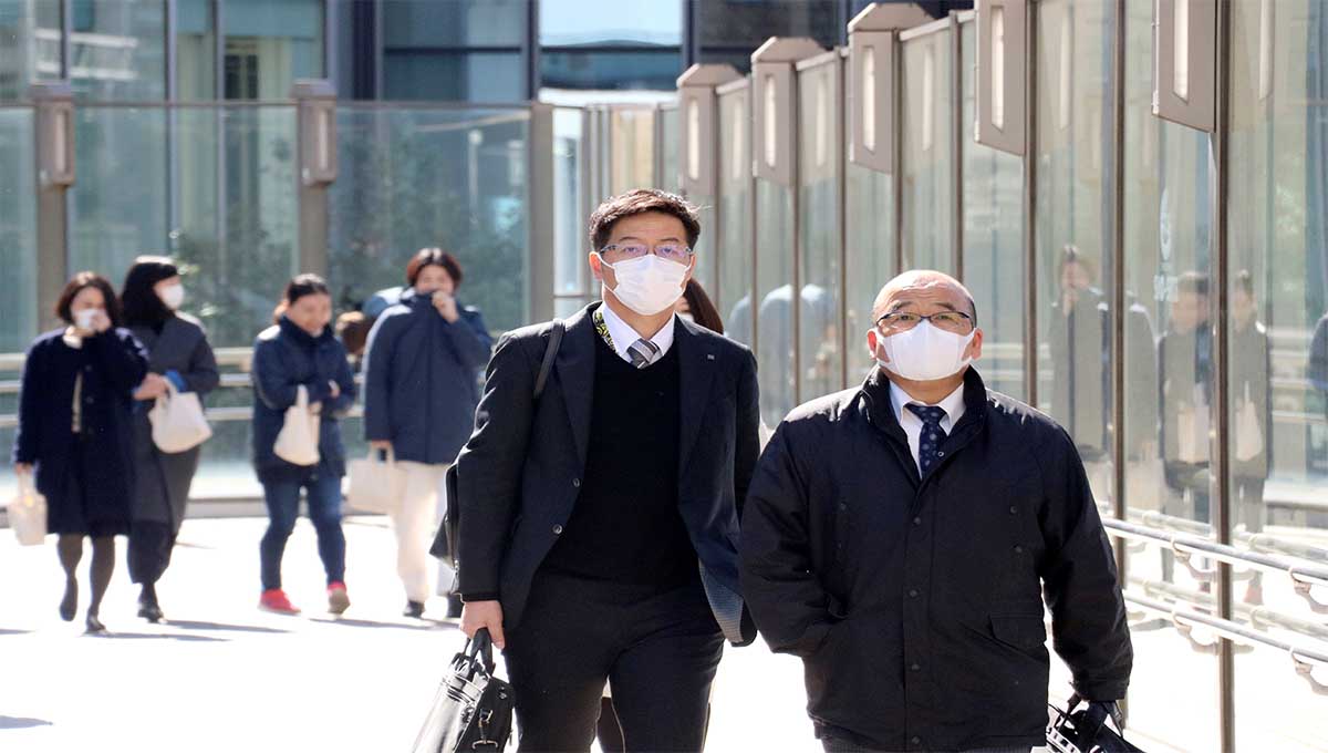 Caminantes en Japón protegiéndose de la nueva cepa