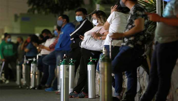 Jóvenes esperan a rellenar tanques de oxígeno en CDMX