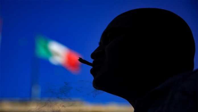 Consumidor de marihuana frente a bandera de México