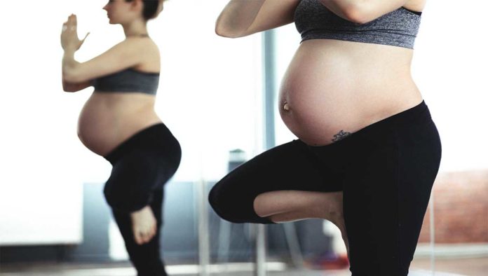 Mujer practica yoga prenatal